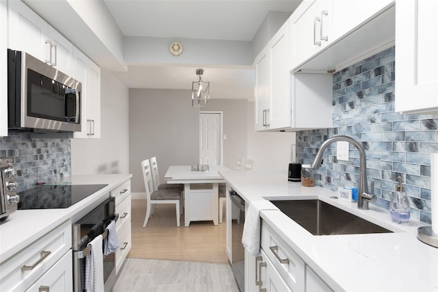 kitchen featuring white cabinetry, sink, and black appliances