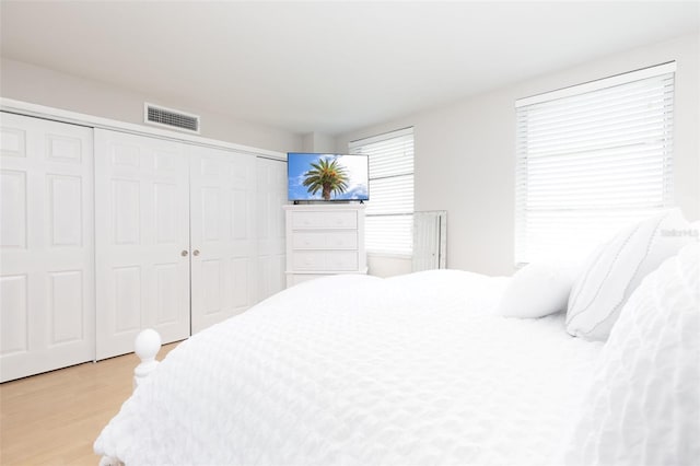 bedroom with light wood-type flooring and a closet