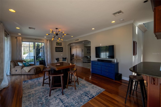 dining space with crown molding, dark hardwood / wood-style flooring, and a chandelier