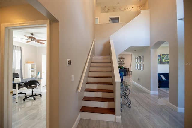 staircase featuring ceiling fan