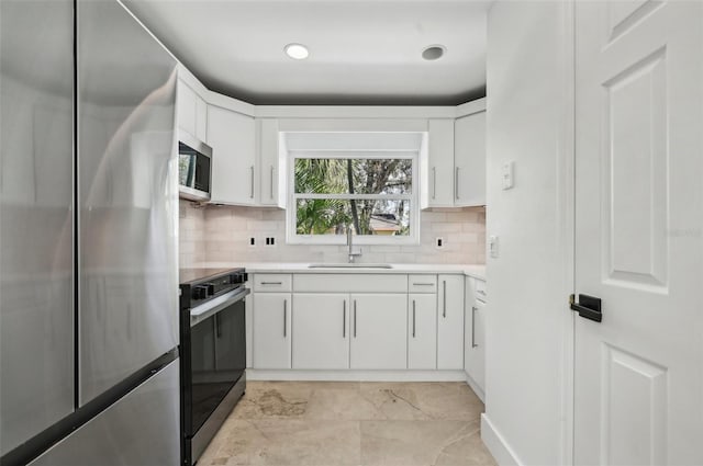 kitchen featuring sink, decorative backsplash, stainless steel appliances, and white cabinets