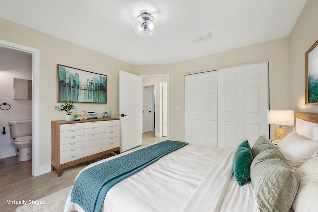 bedroom with ensuite bathroom and a closet