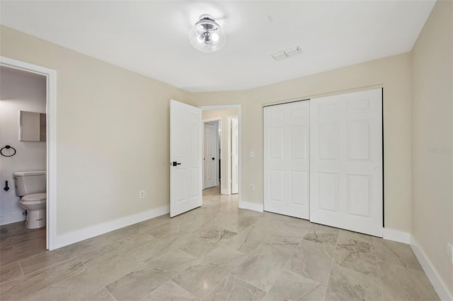 unfurnished bedroom with ensuite bath and a closet