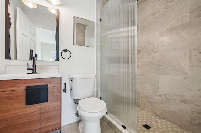 bathroom with vanity, tiled shower, and toilet