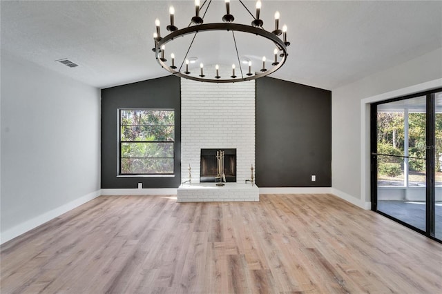 unfurnished living room with lofted ceiling, a textured ceiling, a fireplace, and light hardwood / wood-style floors