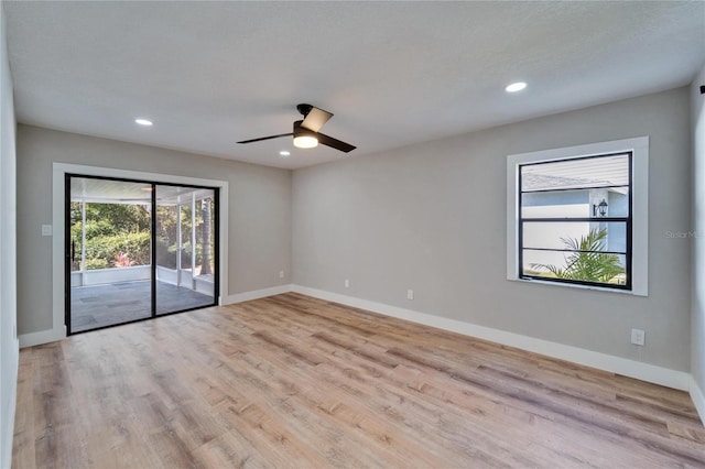 empty room with ceiling fan and light hardwood / wood-style flooring