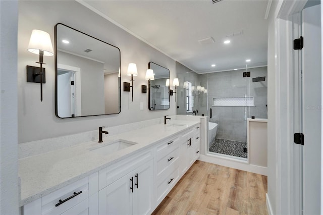 bathroom featuring vanity, hardwood / wood-style floors, crown molding, and independent shower and bath