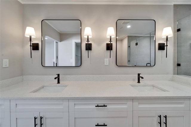 bathroom with a shower with door, vanity, and ornamental molding