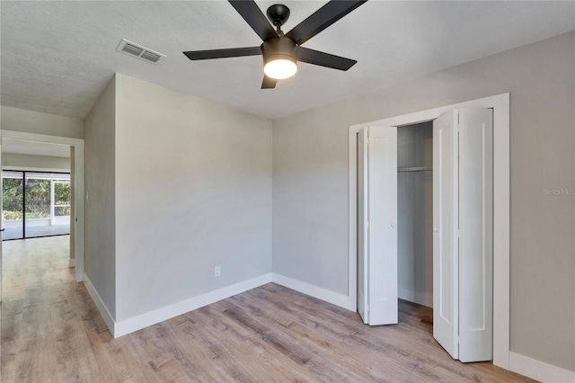 unfurnished bedroom featuring light hardwood / wood-style floors, a closet, and ceiling fan