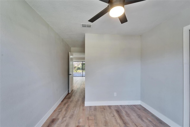 spare room with a textured ceiling, light hardwood / wood-style floors, and ceiling fan