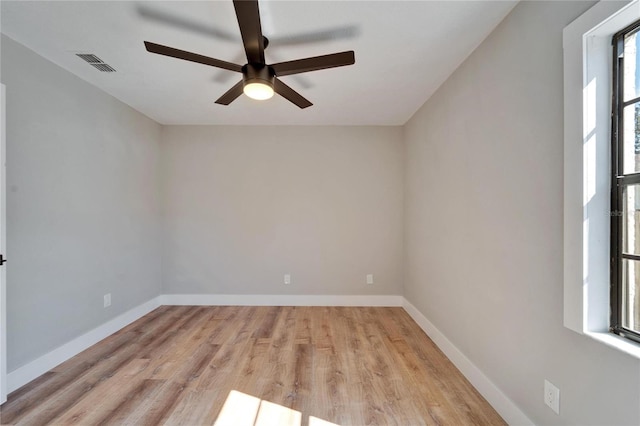 empty room featuring plenty of natural light, light hardwood / wood-style floors, and ceiling fan