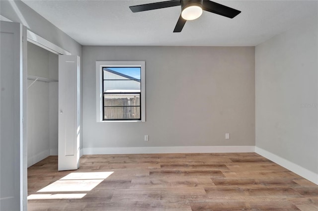 unfurnished bedroom featuring light hardwood / wood-style floors, ceiling fan, and a closet