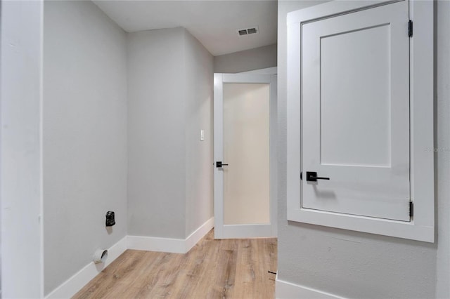 clothes washing area featuring light wood-type flooring