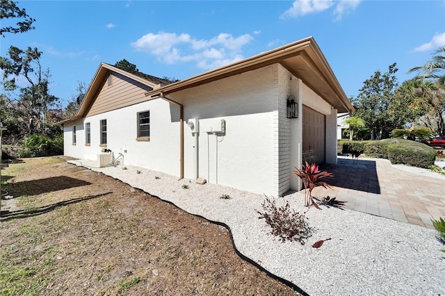 view of home's exterior with a garage and a patio