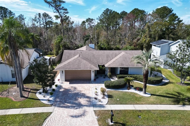 ranch-style house featuring a garage and a front lawn