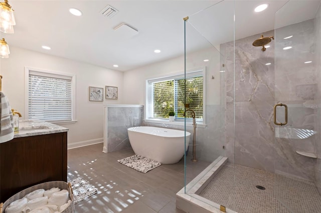 bathroom with tile patterned flooring, vanity, and separate shower and tub