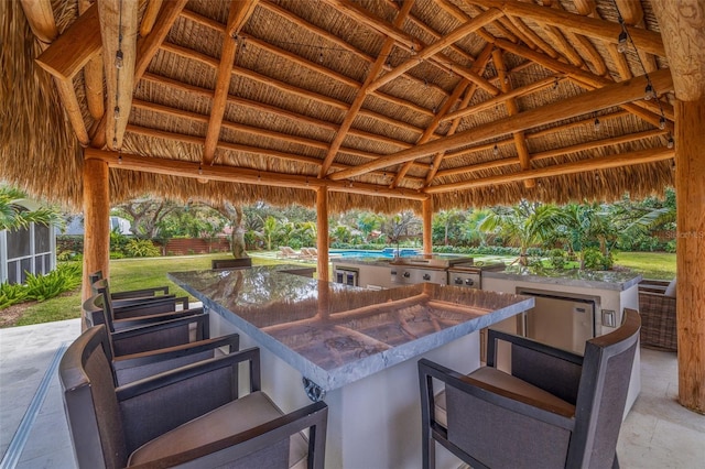 view of patio / terrace featuring a gazebo and exterior bar