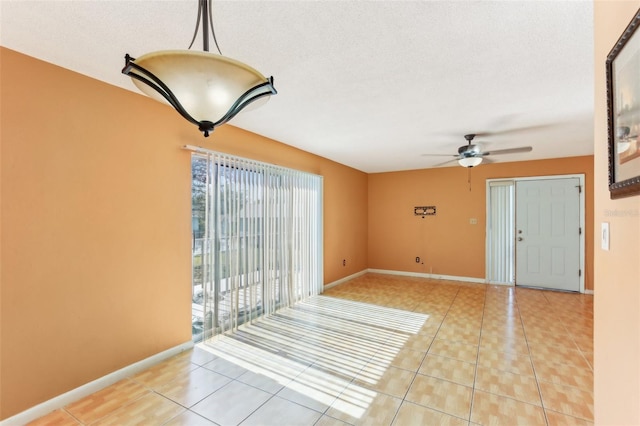 interior space featuring ceiling fan, a textured ceiling, and light tile patterned floors