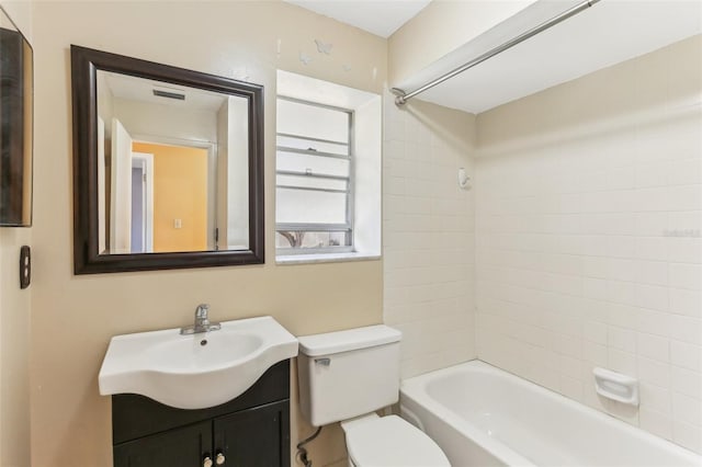 full bathroom featuring tiled shower / bath combo, vanity, and toilet