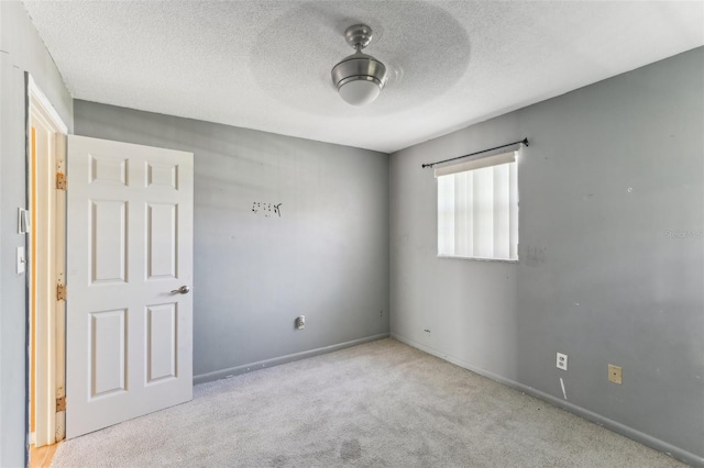 carpeted spare room with ceiling fan and a textured ceiling