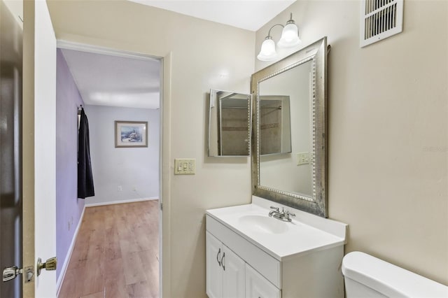 bathroom with vanity, toilet, and wood-type flooring