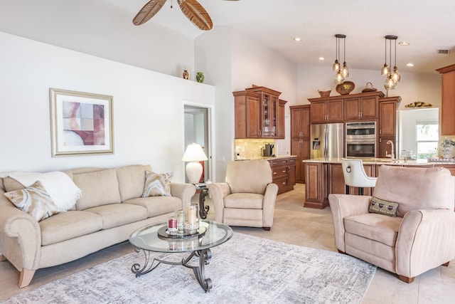 tiled living room featuring a high ceiling, sink, and ceiling fan