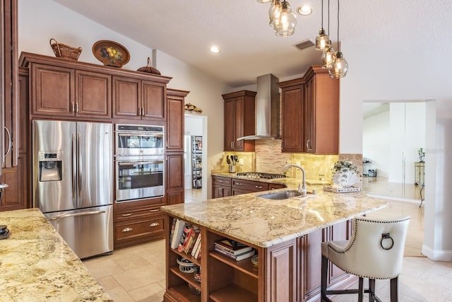 kitchen featuring wall chimney exhaust hood, hanging light fixtures, kitchen peninsula, stainless steel appliances, and decorative backsplash