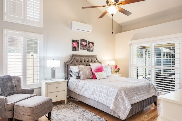 bedroom with hardwood / wood-style flooring, lofted ceiling, a wall mounted AC, and ceiling fan