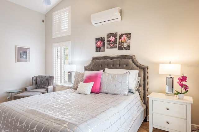 bedroom with lofted ceiling, hardwood / wood-style flooring, and a wall mounted AC