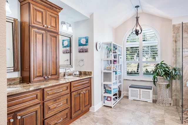 bathroom with lofted ceiling, vanity, and an inviting chandelier