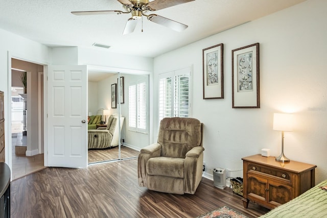 bedroom featuring dark wood-type flooring, a closet, and ceiling fan