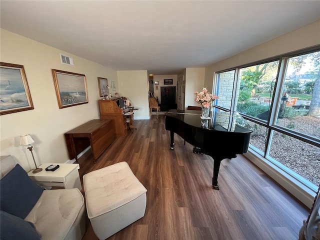 living area with visible vents and wood finished floors