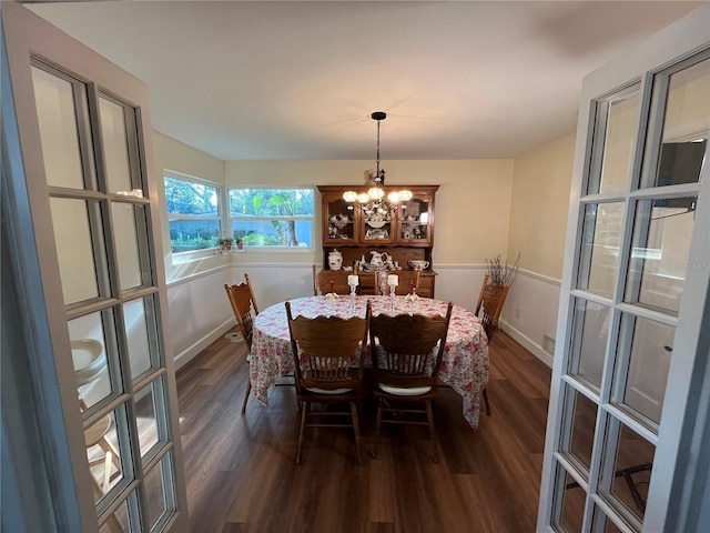 dining space with baseboards, a chandelier, and dark wood finished floors