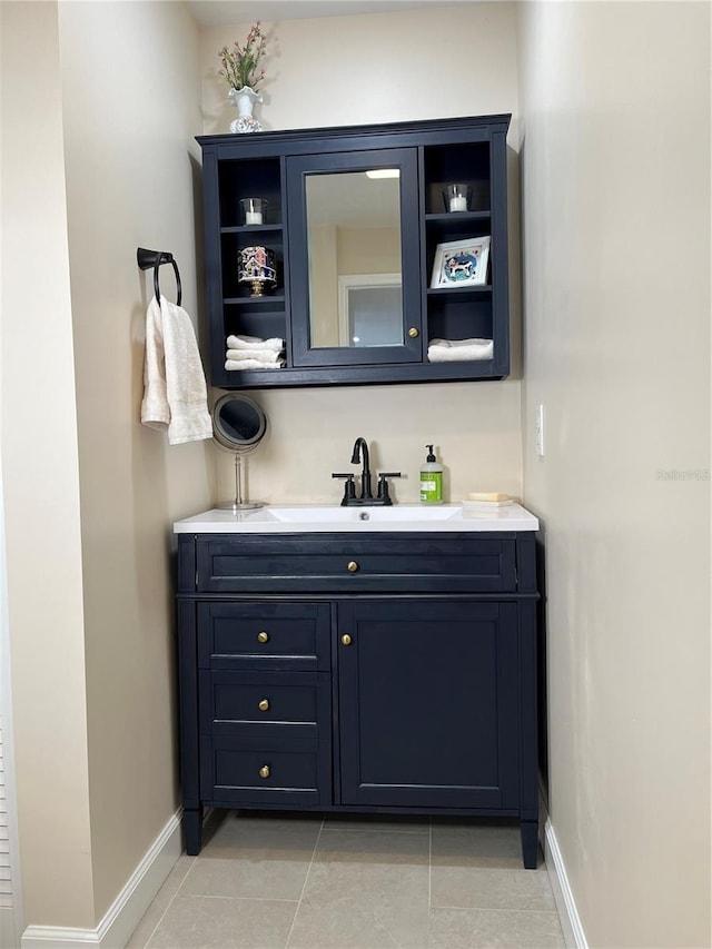 bathroom with vanity, baseboards, and tile patterned floors