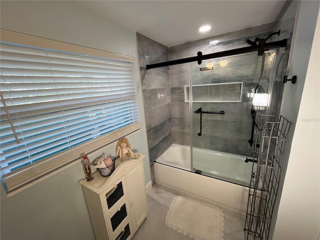 bathroom featuring marble finish floor and bath / shower combo with glass door