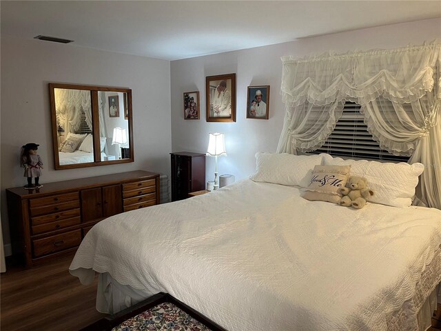 bedroom featuring visible vents and dark wood finished floors