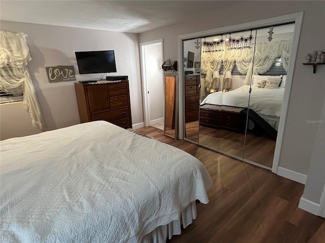 bedroom with a closet, baseboards, and wood finished floors