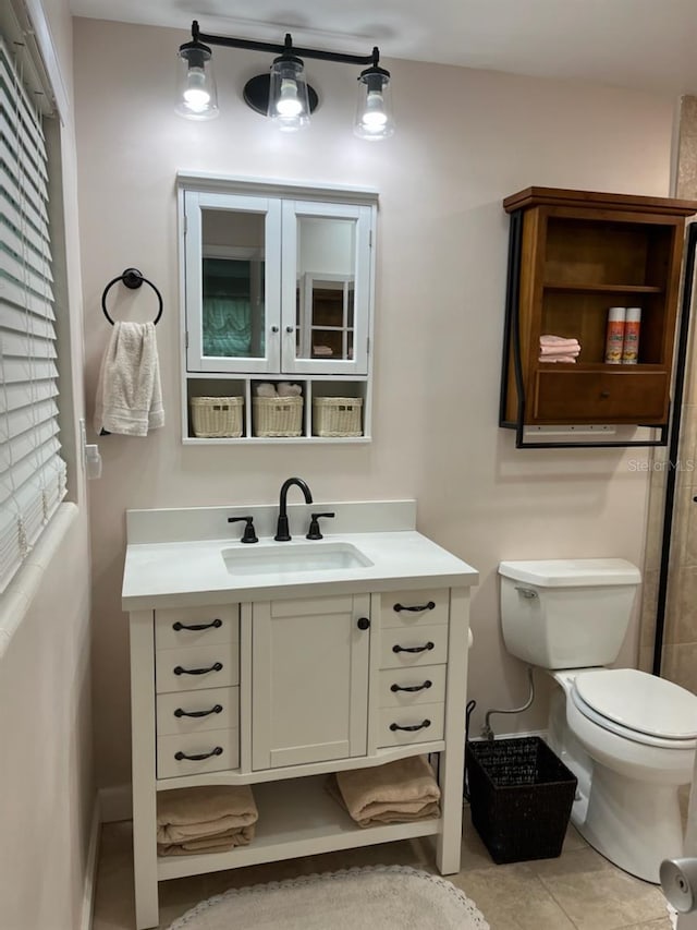 bathroom featuring vanity, tile patterned flooring, and toilet