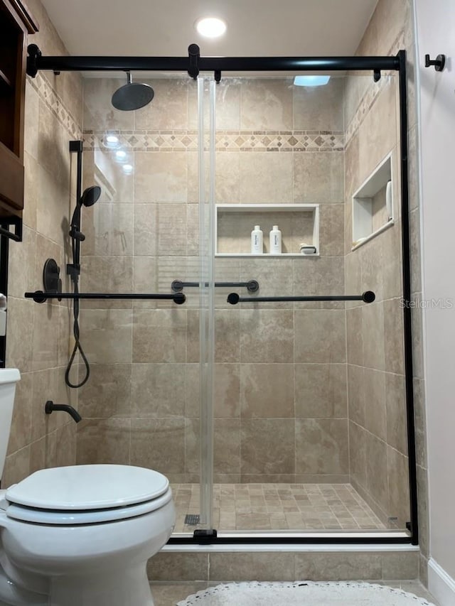 bathroom featuring a shower stall and toilet