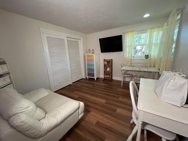 living area with baseboards and dark wood finished floors