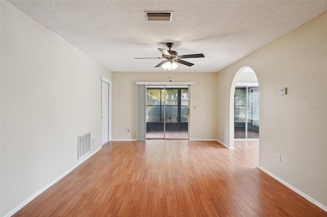 unfurnished room with ceiling fan, light hardwood / wood-style flooring, and a textured ceiling