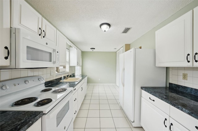 kitchen featuring sink, backsplash, white cabinets, light tile patterned floors, and white appliances