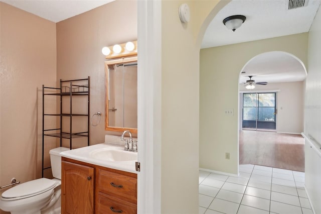 bathroom with tile patterned flooring, vanity, ceiling fan, and toilet