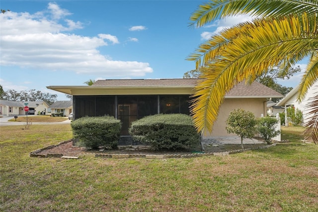 view of property exterior with a yard and a sunroom