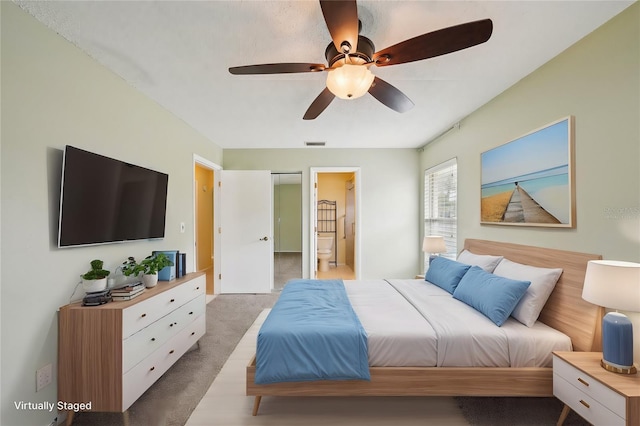 bedroom featuring carpet floors, connected bathroom, and ceiling fan