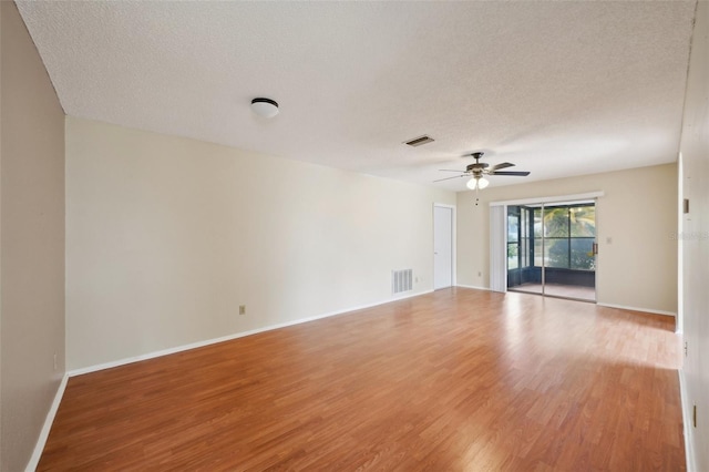 unfurnished room featuring ceiling fan, light hardwood / wood-style floors, and a textured ceiling