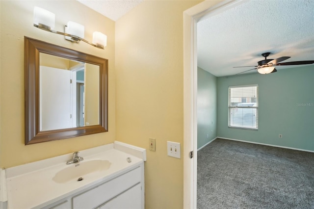 bathroom with ceiling fan, vanity, and a textured ceiling