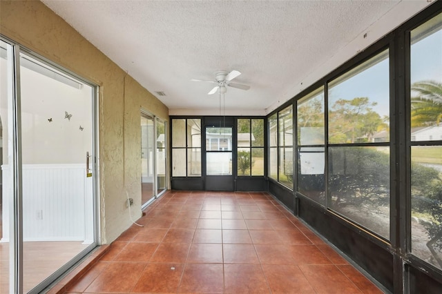 unfurnished sunroom with ceiling fan