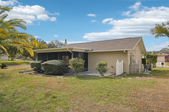 rear view of property with a sunroom and a lawn