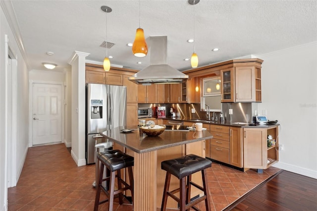 kitchen with a kitchen bar, sink, pendant lighting, island exhaust hood, and stainless steel appliances